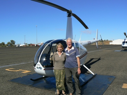 John and Judy with helicopter at Connellan Airport, Yulara